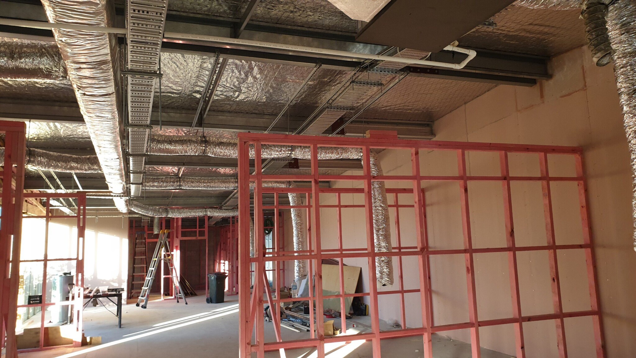 A technician installing air conditioning system in a room under construction