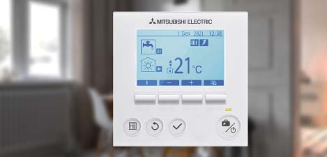 A white electronic thermostat in a room. It enables smart monitoring.