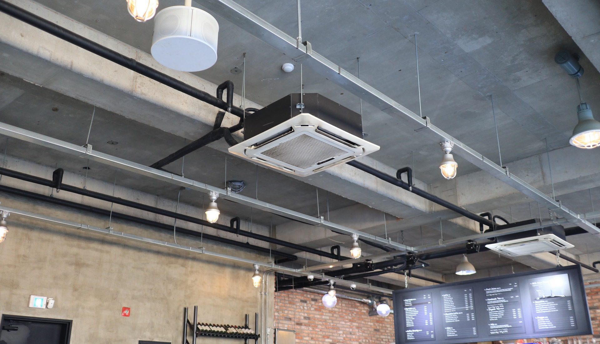 A spacious room with a ceiling fan and illuminated lights hanging from the ceiling.