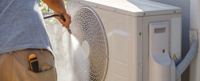 air conditioning compressor outdoor unit cleaning service with water spray.