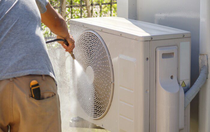 air conditioning compressor outdoor unit cleaning service with water spray.