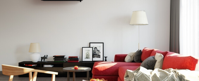 Black Mitsubishi Electric high wall heat pump mounted above a living room sofa